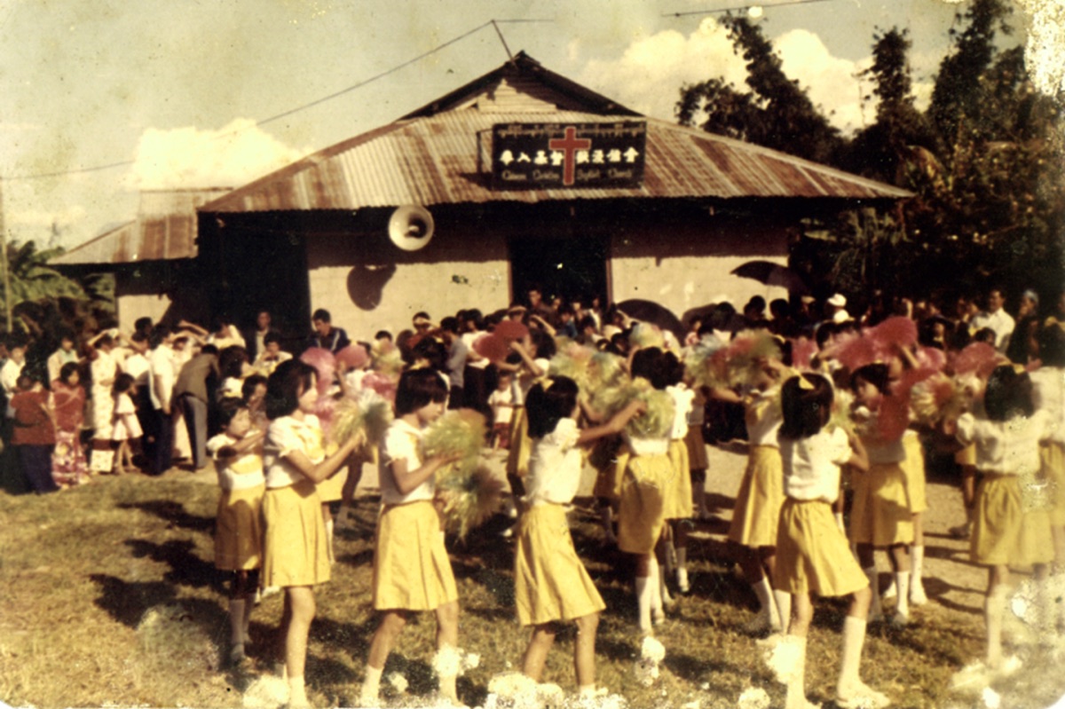 1987 年圣诞节，穿黄色裙装的学生列队在旧礼拜堂前表演舞蹈
